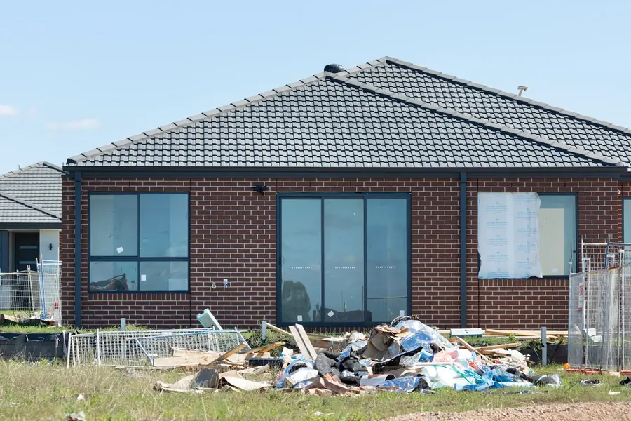 Construction debris beside a newly built brick home